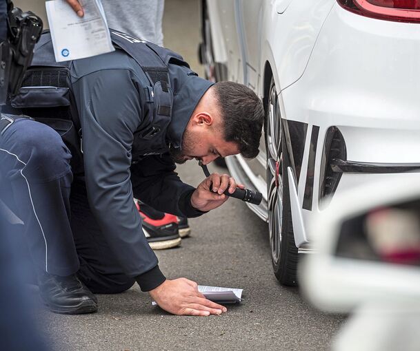 Ein Polizist überprüft am „Car-Freitag“ ein Fahrzeug auf einem Parkplatz. Foto Christian Knieps/dpa