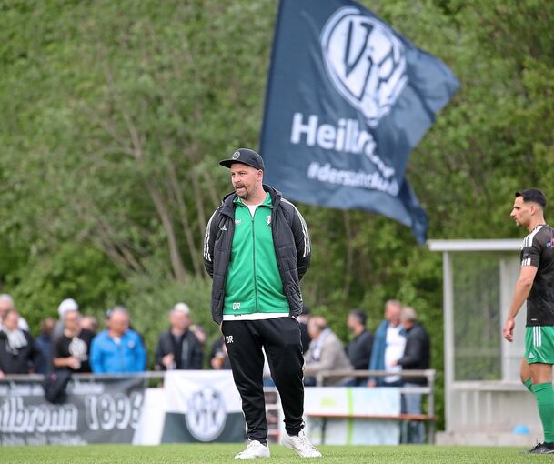 TSV-Heimerdingen-Trainer Daniel Riffert vor einer VfR-Heilbronn-Fahne. Der TSV will die Heilbronner nun wieder von der Spitze verdrängen.
