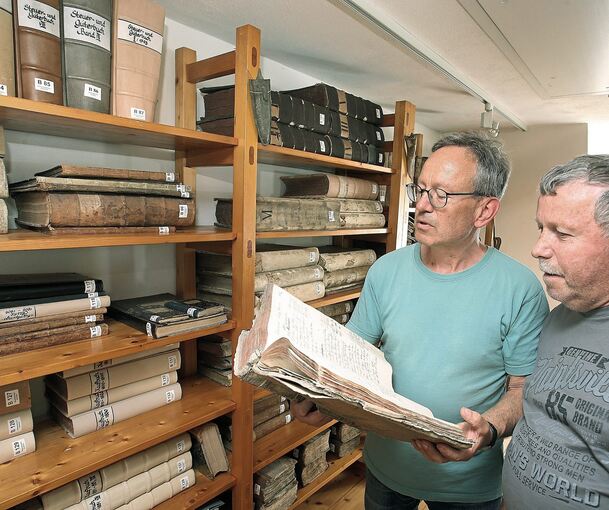 Roland Kögele (links) sucht mit Norbert Schmid Informationen über dessen Familie im ältesten Bestand des Sersheimer Gemeindearchivs.