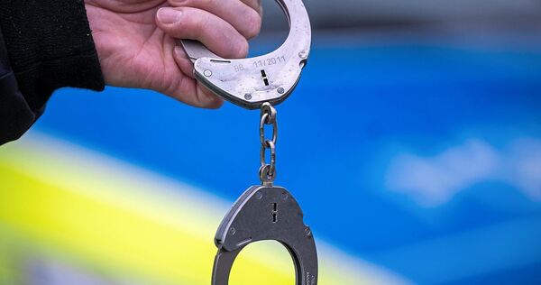 Ein Polizist mit Handschellen. Ein Polizist mit Handschellen.
