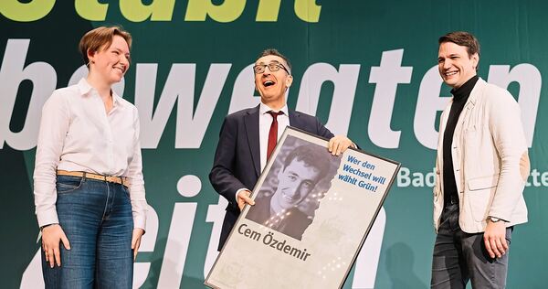 Kinder, wie die Zeit vergeht: Die Kreisvorstandsmitglieder Amelie Kalt und Lars Schweizer (rechts) überreichen Cem Özdemir auf d Kinder, wie die Zeit vergeht: Die Kreisvorstandsmitglieder Amelie Kalt und Lars Schweizer (rechts) überreichen Cem Özdemir auf dem Parteitag im Forum im Dezember ein Wahlplakat aus dem Jahr 1994.