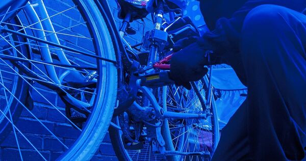 Ein Fahrraddieb macht sich an einem Fahrrad zu schaffen. Ein Fahrraddieb macht sich an einem Fahrrad zu schaffen.