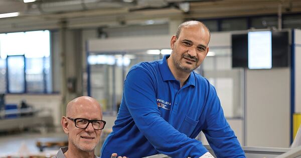In einer Frizlen-Werkshalle: Michael Westreicher (links) und Tareq Alhallak an einem Widerstand mit Schaltschrank. In einer Frizlen-Werkshalle: Michael Westreicher (links) und Tareq Alhallak an einem Widerstand mit Schaltschrank.