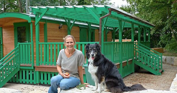 Leiterin Birgit Bernhard und Kindergartenhund Casey gehören zum Stammpersonal der städtischen Kita Pusteblume in Poppenweiler. D Leiterin Birgit Bernhard und Kindergartenhund Casey gehören zum Stammpersonal der städtischen Kita Pusteblume in Poppenweiler. Die neue Naturgruppe mit Bauwagen und Co. ist nur einen Steinwurf entfernt.