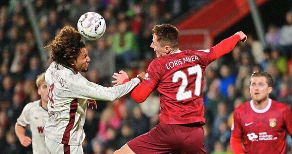 Der Großaspacher Loris Maier (rechts) geht beherzt ins Kopfballduell mit dem Augsburger Han-Noah Massengo. Foto: Jan-Philipp Str Der Großaspacher Loris Maier (rechts) geht beherzt ins Kopfballduell mit dem Augsburger Han-Noah Massengo.